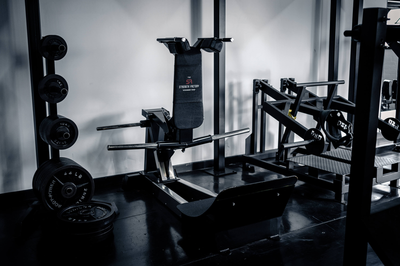 Plate-loaded leg machines and weight plates at Strength Factory, Bolton